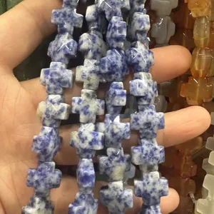Vue détaillée de perles en pierre naturelle en forme de croix pour la création de bijoux.