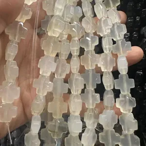 Gros plan détaillé de perles en agate naturelle en forme de croix pour bijoux DIY