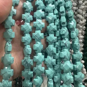 Gros plan de perles en pierre naturelle en forme de croix turquoise pour bijoux DIY.
