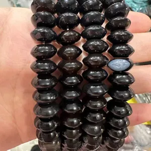 Detailed close-up of translucent black natural stone saucer beads for jewelry making