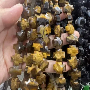Gros plan détaillé de perles en forme de croix en pierre d'œil de tigre naturelle DIY