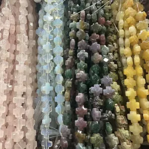 Vue macro de perles en forme de croix en pierre naturelle facettée pour bijoux artisanaux