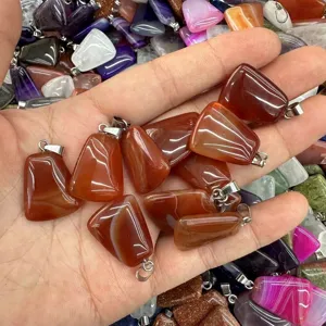 Natural red agate trapezoidal pendants held in hand with shiny silver metal bails