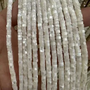 Close-up view of natural white mother of pearl square shell spacer beads showing iridescent luster