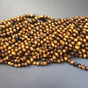Macro detail of natural tiger eye stone beads with golden brown chatoyancy texture