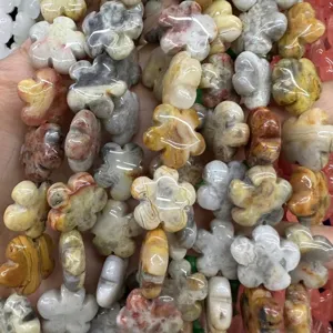 Macro detail of various natural stone beads shaped like five-petal plum blossoms for DIY
