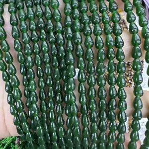 Gros plan de perles en pierre gemme goutte vert foncé pour accessoires de bijoux DIY