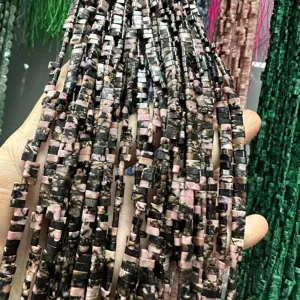 Gros plan de perles rectangulaires en pierre naturelle rose et noire 3x5mm pour bijoux.