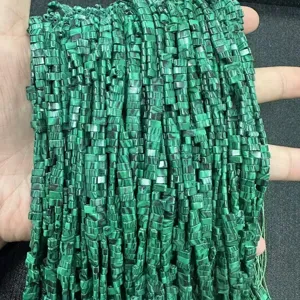 Vue macro de perles en pierre de malachite verte de 3x5 mm à double trou pour bijoux