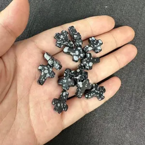 Macro detail of 12x16mm snowflake obsidian cross beads for DIY jewelry making