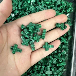 Macro view of 12x16mm green malachite style cross beads for DIY jewelry making.