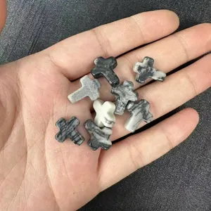 Detailed view of 12x16mm black and white marble stone cross beads with vertical holes