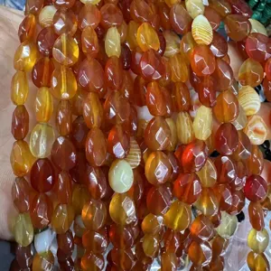 Close-up view of faceted orange carnelian agate water-drop beads for DIY jewelry making projects
