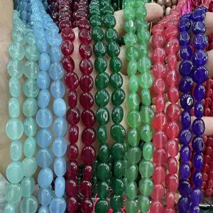 Gros plan de perles de calcédoine ovales 8x10mm en diverses couleurs vives