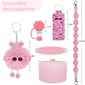 Vista dettagliata di accessori rosa per tazze, con ciondolo in peluche e tracolla con margherite.