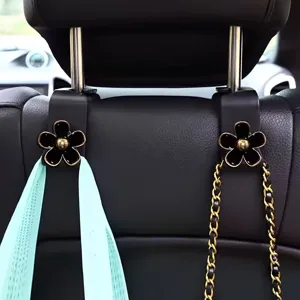 Car seat backrest hook with black flower design, universal vehicle hanger for bags and purses.