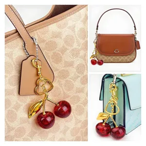 Gold cherry bag charm with red glitter cherries and heart ring for handbag decoration.
