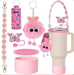 Set accessori per tazza Stanley rosa con tracolla margherita, stivale silicone e portachiavi.