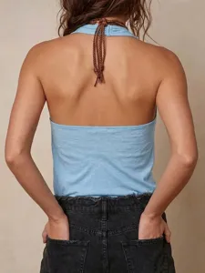 Dettaglio posteriore del top halter blu senza maniche e schiena scoperta con elegante cinturino.