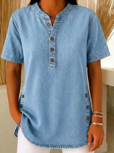 Detail view of women's short sleeve denim tunic shirt with front button placket and side split.