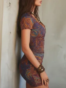 Gros plan détail robe mini femme vintage imprimé cachemire col V coupe ajustée.