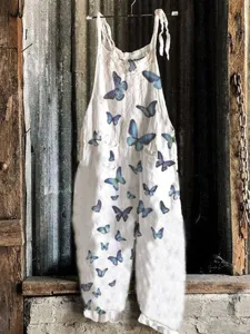 White linen blend sleeveless wide-leg jumpsuit featuring stunning blue butterfly print design.