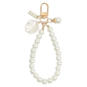 Elegant white pearl keychain and bag charm featuring a shell pendant and secure metal clasp.