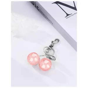 Detailed shot of sparkling pink resin cherry keychain with silver metal clasp and ring hook.