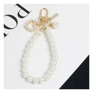 Elegante portachiavi di perle bianche finte con ciondolo a cuore e accessori dorati.