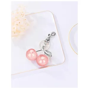 Sparkling pink cherry keychain close-up, glossy resin balls with silver metal hardware.