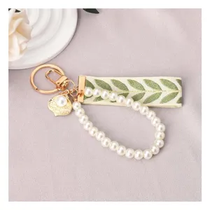 Elegante portachiavi di perle con nastro ricamato a foglie verdi e gancio dorato da donna.
