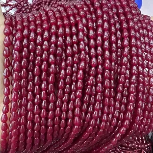 Gros plan sur des perles de calcédoine rouge en forme de goutte pour le bricolage.