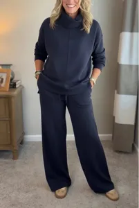 Detailed view of the navy blue turtleneck sweatshirt and matching wide-leg pants set.