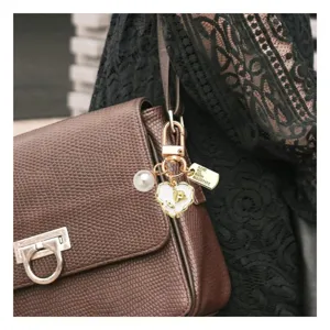 Detail view of pearl heart keychain handbag pendant, stylish rose charm for women bags.
