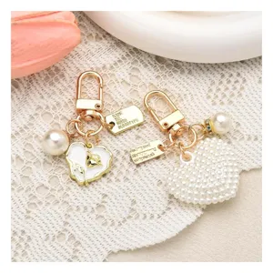Elegant pearl keychain set with heart-shaped rose pendant and gold hardware for women bags.