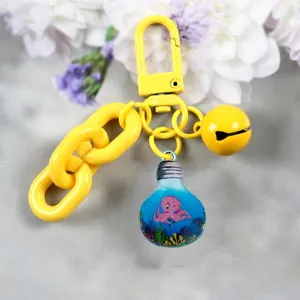 Detail view of a cute candy color alloy keychain with lightbulb octopus pendant and bell charm.