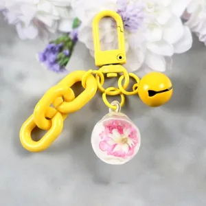 Lindo llavero amarillo para bolso con bola de cristal de flor seca y colgante de campana.