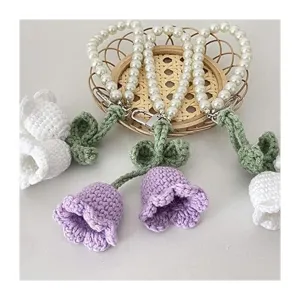 Detailansicht kreativer Häkelblumen-Schlüsselanhänger mit edlen Perlenketten und Strickblumen.