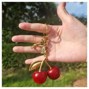 Gold-toned cherry keychain with glitter red cherries and letter A charm, cute bag charm pendant.