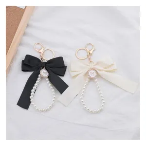 Elegante set di portachiavi con fiocco di perle per borse, chiavi d'auto e accessori moda.
