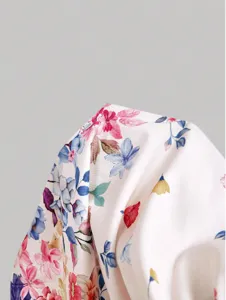 Close-up detail of women floral print dress fabric, showing soft texture and colorful pattern.