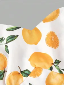 Close-up detail of women's summer vacation dress fabric featuring vibrant watercolor lemon print.