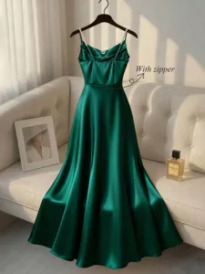 Detailed view of elegant green satin slip dress with pearl straps and zippers.