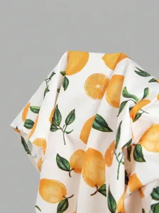 Close-up detail of stylish orange and leaf print fabric, smooth texture, elegant resort wear.
