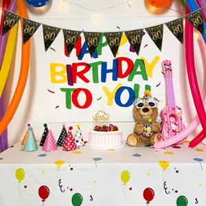 Black gold 80th birthday banner party decoration detail showing festive setting setup.