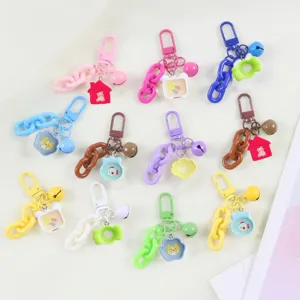 Detailed view of colorful plastic chain keychains with cute cartoon pendants and bells.