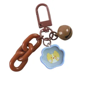 Creative drip glue keychain with brown chain, bell, and cute cartoon dog pendant detail.