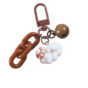 Cute brown chain keychain DIY bag charm with fluffy paw and bell accessory for women.