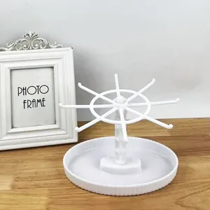 White rotating jewelry display stand keychain holder desktop organizer with hooks and round base.