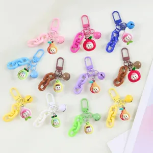 Detailansicht niedlicher bunter Fruchtpuppen-Schlüsselanhänger mit Plastikketten und kleinen Glocken.